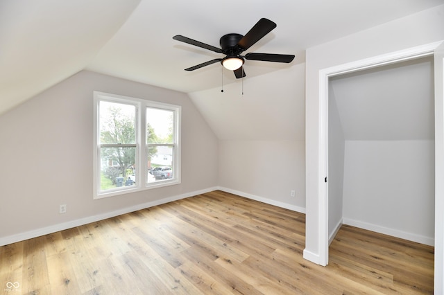 bonus room with light wood-style floors, lofted ceiling, baseboards, and a ceiling fan