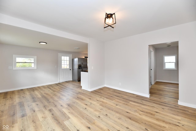 empty room with light wood-style flooring and baseboards