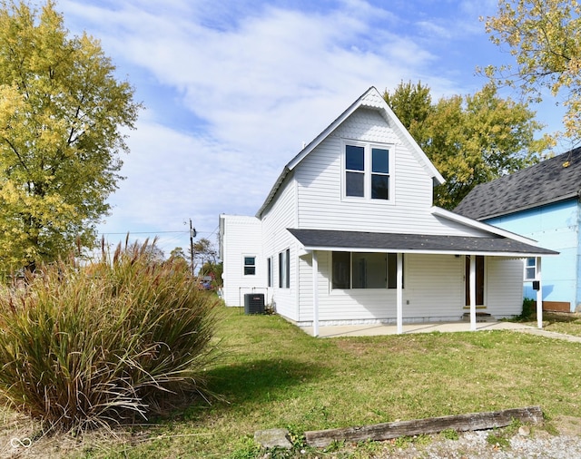 rear view of house featuring a shingled roof, a patio area, a lawn, and central AC unit