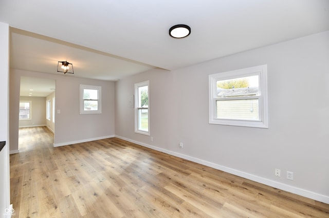 empty room with light wood-style flooring and baseboards