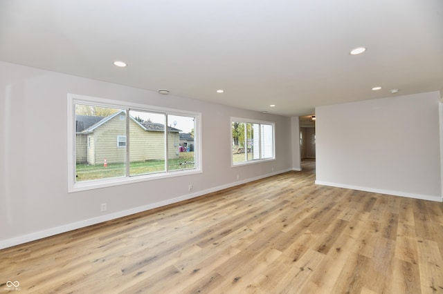 empty room with baseboards, light wood-type flooring, and recessed lighting