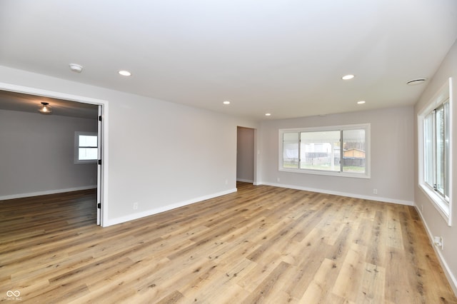 empty room featuring light wood-style flooring, baseboards, and recessed lighting