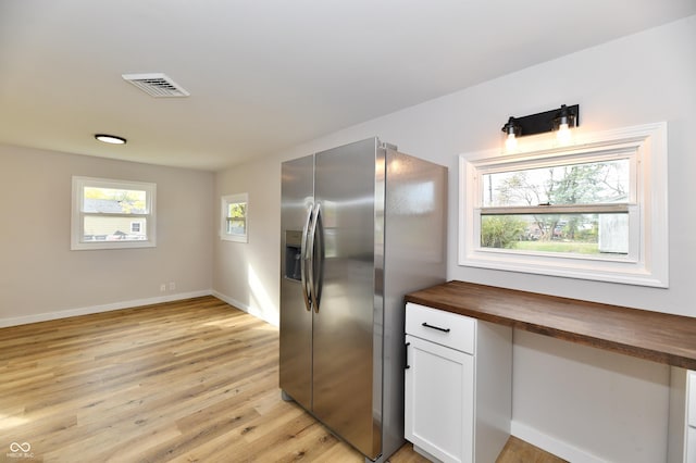 kitchen featuring visible vents, wooden counters, light wood-style flooring, white cabinetry, and stainless steel fridge with ice dispenser