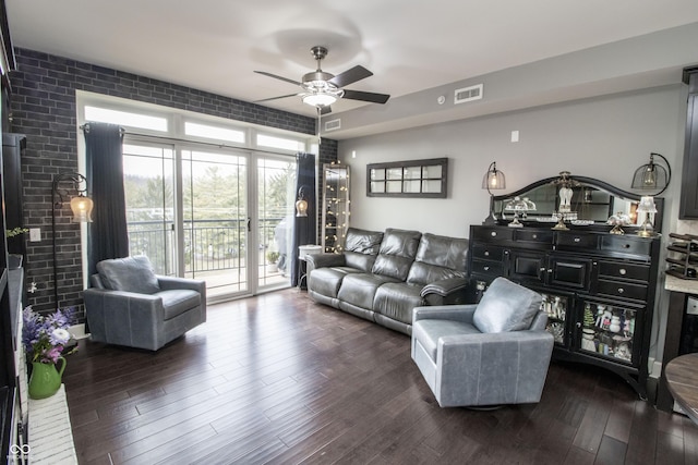 living room featuring a ceiling fan, visible vents, and dark wood finished floors