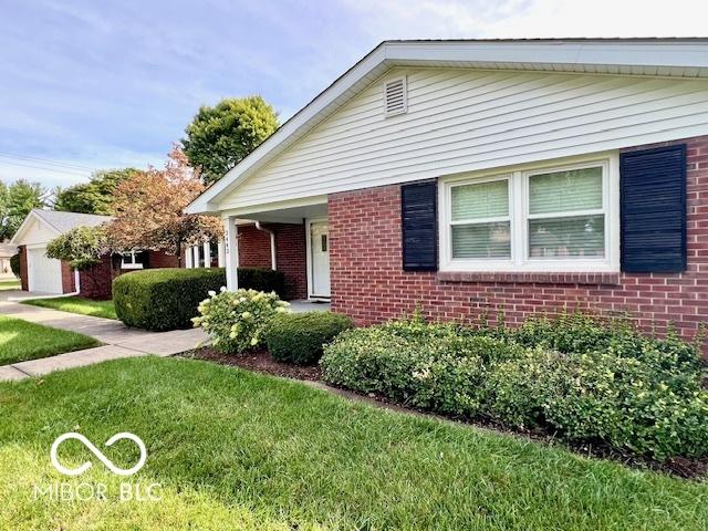 view of front of home featuring a front lawn and brick siding