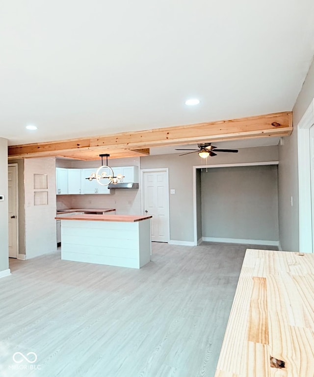 kitchen with ceiling fan, baseboards, white cabinets, a center island, and light wood finished floors