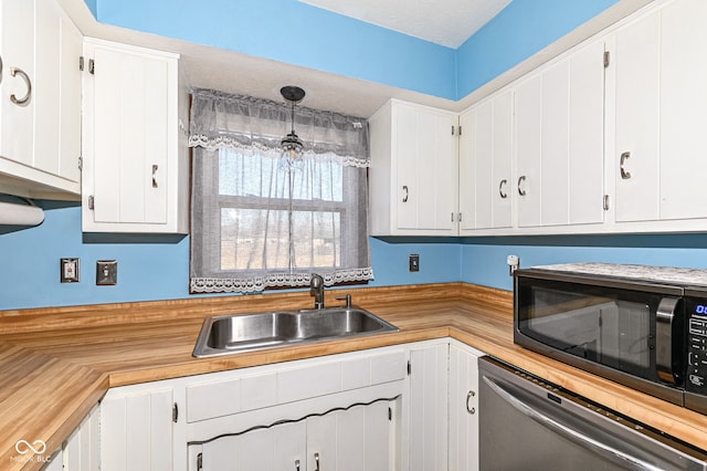 kitchen with dishwasher, black microwave, white cabinets, and a sink