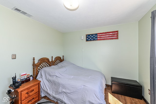 bedroom with visible vents and wood finished floors