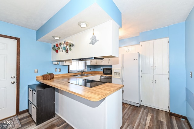 kitchen featuring dark wood-type flooring, white cabinets, a sink, a peninsula, and black appliances