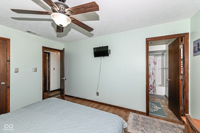 bedroom featuring visible vents, a ceiling fan, a textured ceiling, wood finished floors, and baseboards