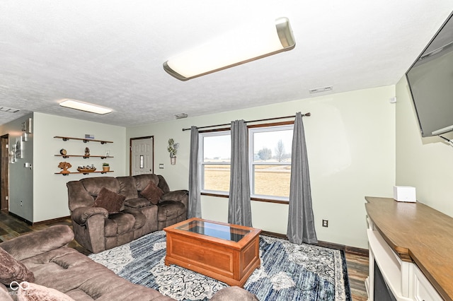 living area with visible vents, dark wood finished floors, a textured ceiling, and baseboards