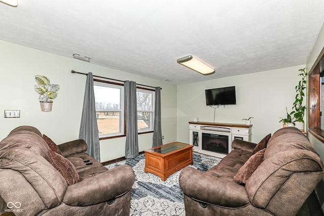 living room featuring a textured ceiling, a fireplace, and visible vents