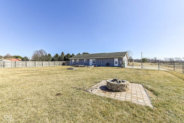 view of yard with a gate, fence, and a fire pit