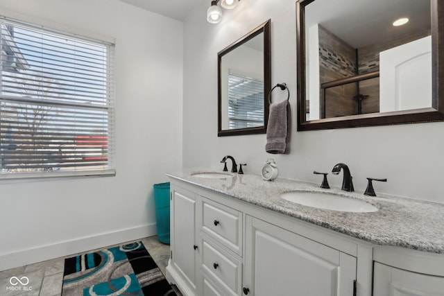1413 S E St, Indianapolis, IN 46225 - bathroom featuring double vanity, a shower stall, baseboards, and a sink