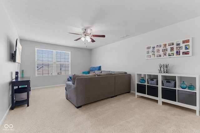 carpeted living area featuring a ceiling fan, baseboards, visible vents, and a textured ceiling