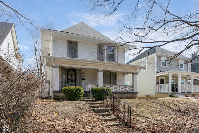 traditional style home featuring a shingled roof and covered porch