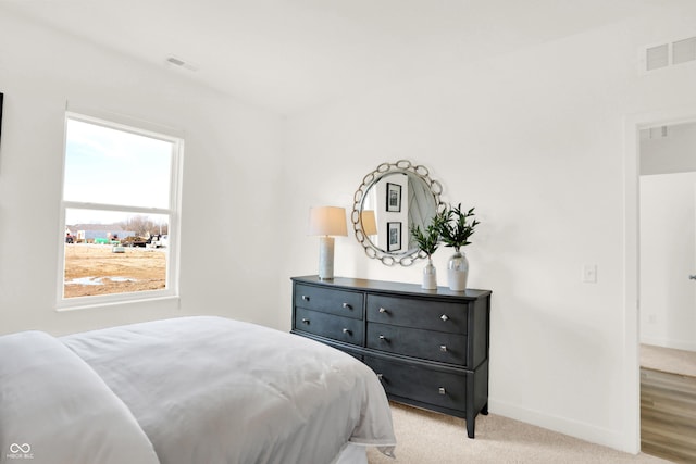 bedroom with light carpet, baseboards, and visible vents