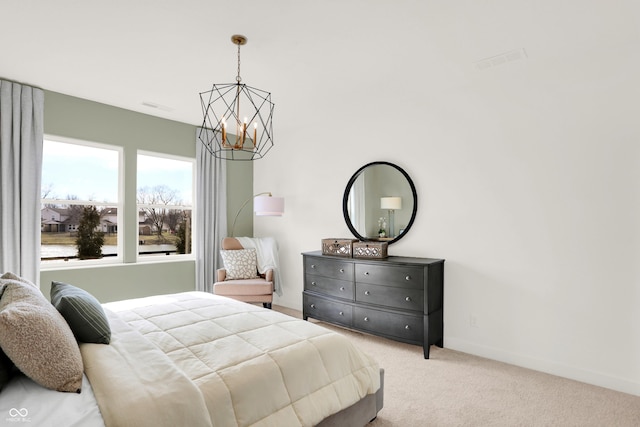 carpeted bedroom with a notable chandelier and baseboards