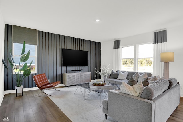 living area featuring baseboards, wood finished floors, and recessed lighting