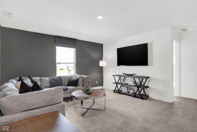 living room featuring visible vents, light carpet, and baseboards