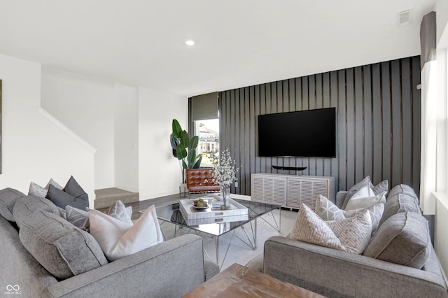 living room featuring recessed lighting, visible vents, an accent wall, wood finished floors, and baseboards