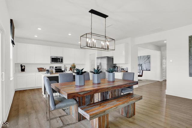 dining area with light wood-style floors, baseboards, and recessed lighting