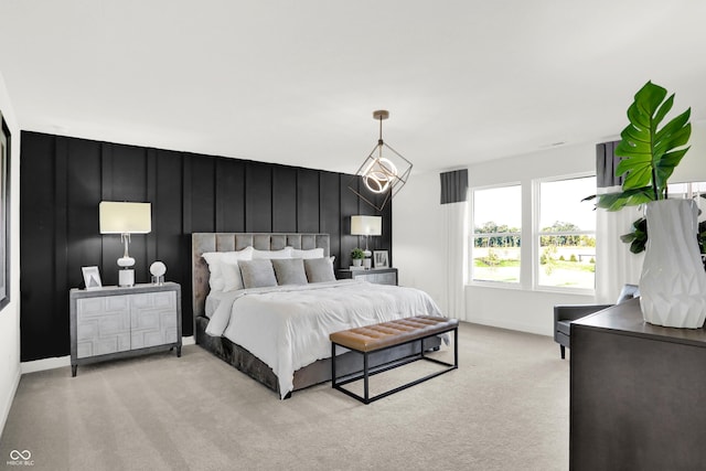 bedroom featuring baseboards, a decorative wall, and light colored carpet