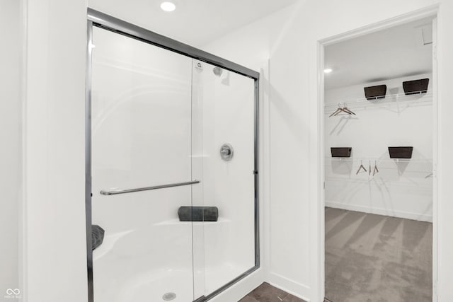 full bath featuring a shower stall, a walk in closet, and recessed lighting