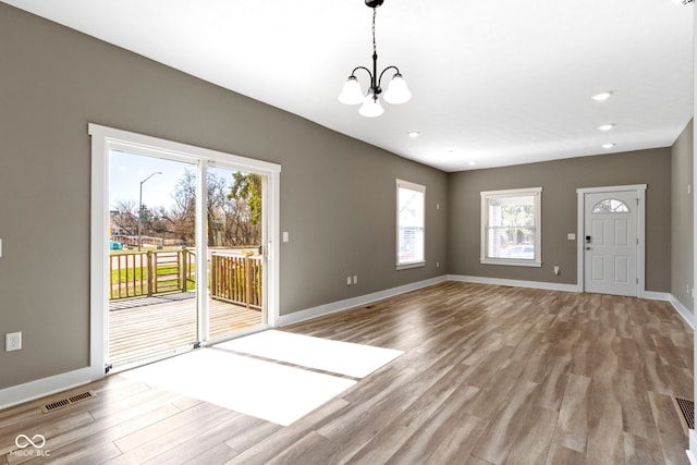 interior space with visible vents, baseboards, a chandelier, recessed lighting, and wood finished floors