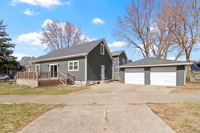 view of front facade featuring a deck, an outdoor structure, concrete driveway, and a detached garage