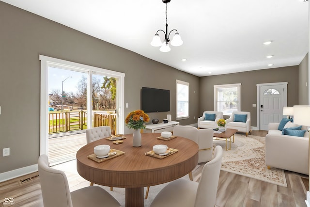 dining space featuring visible vents, a notable chandelier, recessed lighting, light wood finished floors, and baseboards