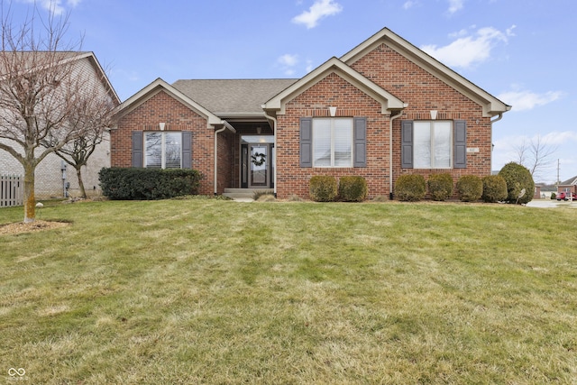 ranch-style home with brick siding, a front yard, and fence