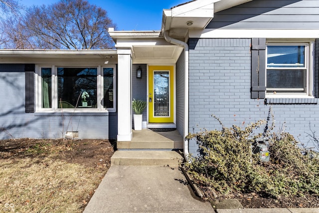 doorway to property with brick siding