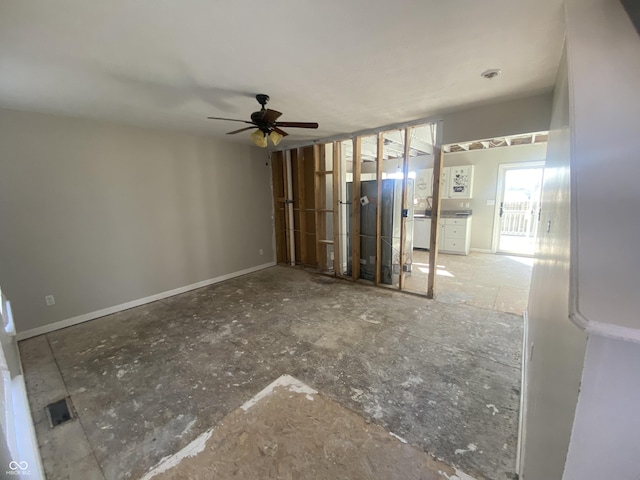 unfurnished living room with a ceiling fan and baseboards