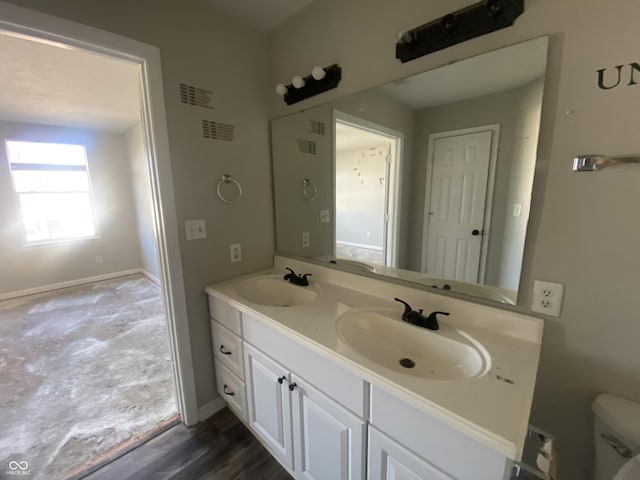 bathroom featuring visible vents, a sink, toilet, and double vanity