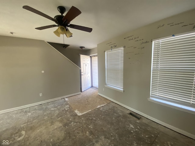 unfurnished living room with a ceiling fan, visible vents, and baseboards