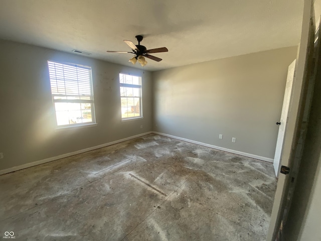 spare room with ceiling fan, visible vents, and baseboards