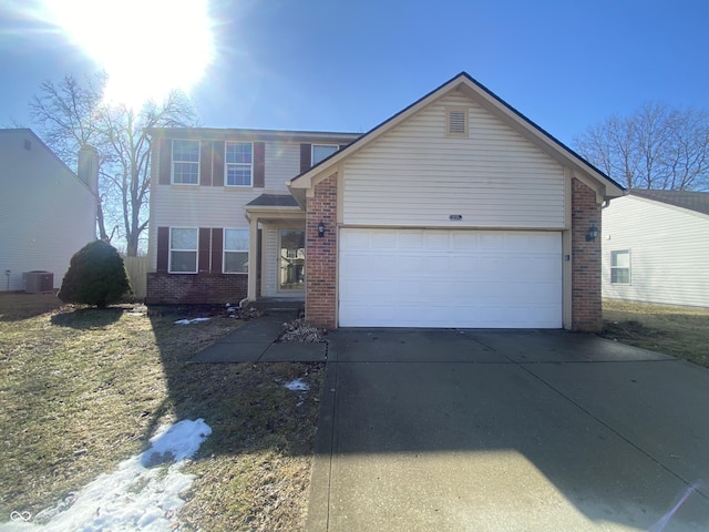 traditional home featuring a garage, concrete driveway, and brick siding