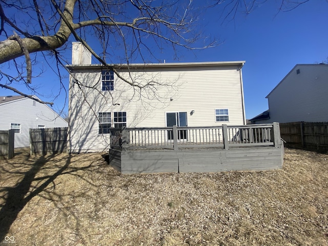 rear view of house with fence and a chimney