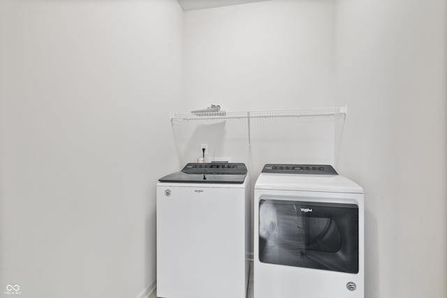 laundry room with laundry area, baseboards, and washing machine and clothes dryer