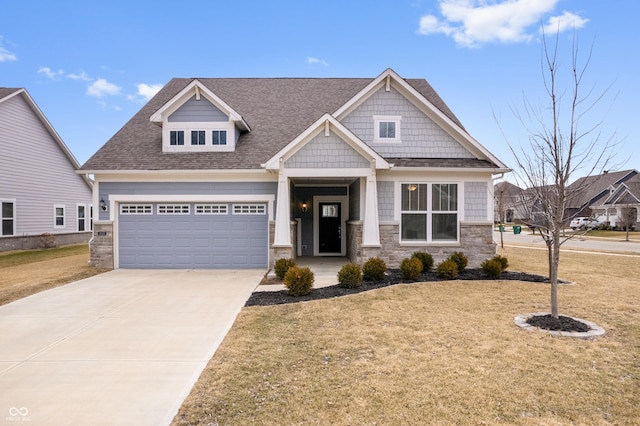 craftsman house featuring driveway, an attached garage, roof with shingles, and a front yard