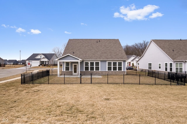 rear view of property with fence, a lawn, and roof with shingles