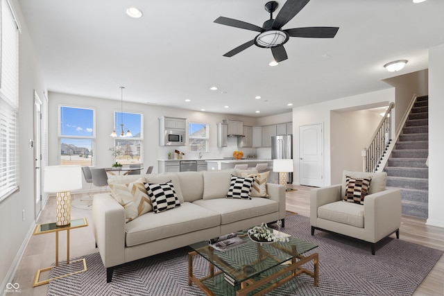 living area featuring light wood-type flooring, stairway, visible vents, and recessed lighting