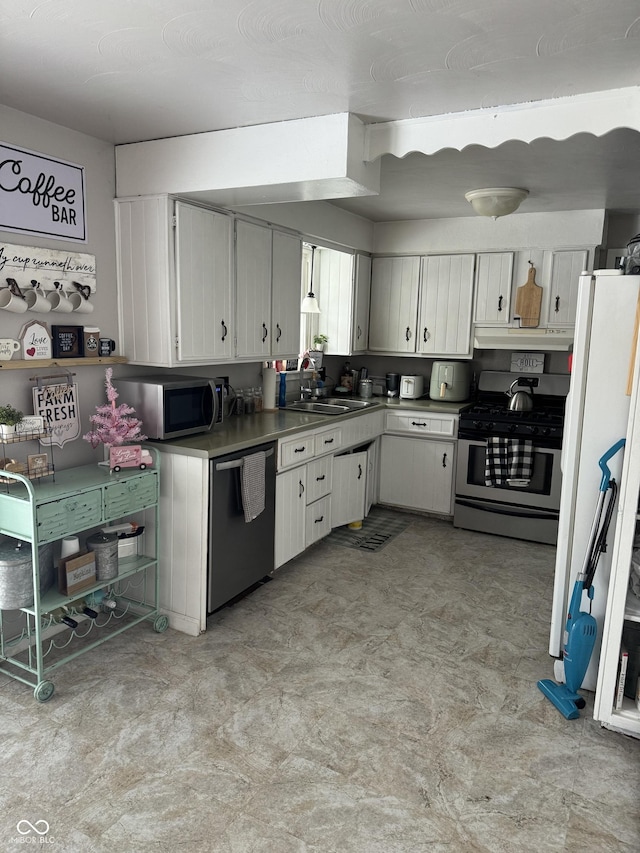 kitchen featuring under cabinet range hood, a sink, white cabinetry, appliances with stainless steel finishes, and light floors