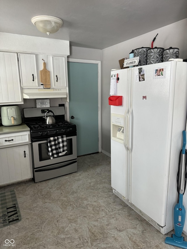 kitchen featuring white refrigerator with ice dispenser, stainless steel gas stove, under cabinet range hood, and white cabinetry