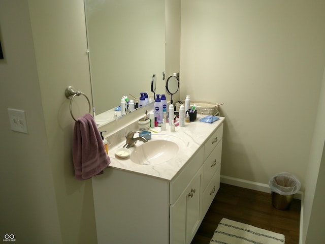 bathroom with vanity, baseboards, and wood finished floors