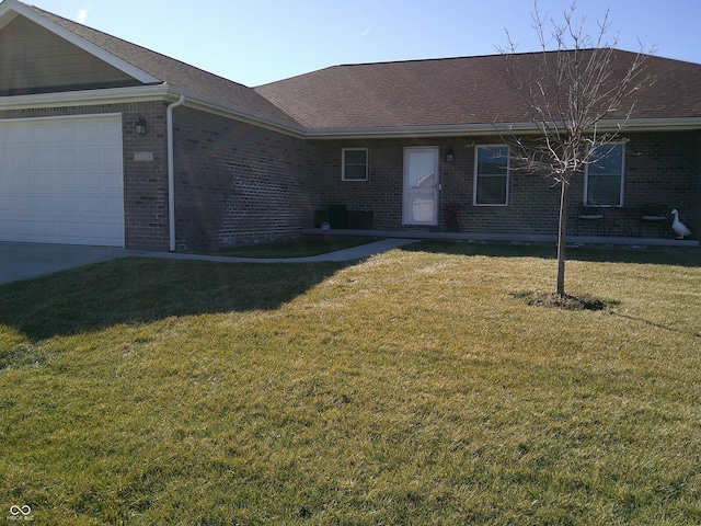 single story home featuring a garage, a front yard, brick siding, and roof with shingles