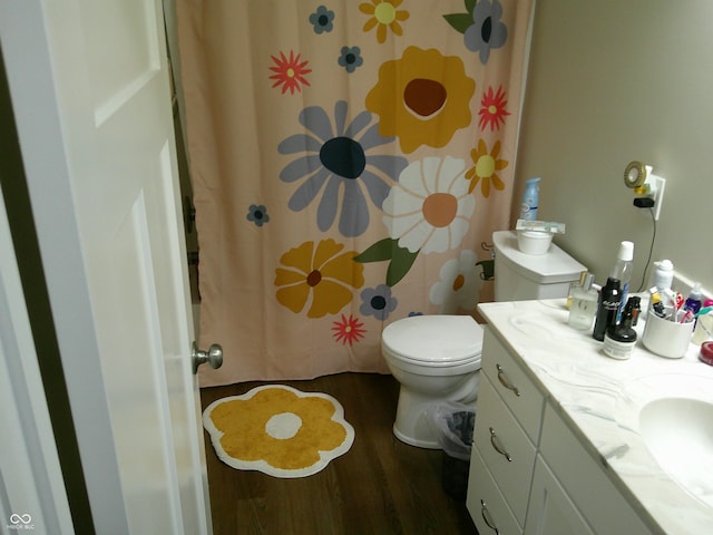 bathroom with toilet, curtained shower, wood finished floors, and vanity