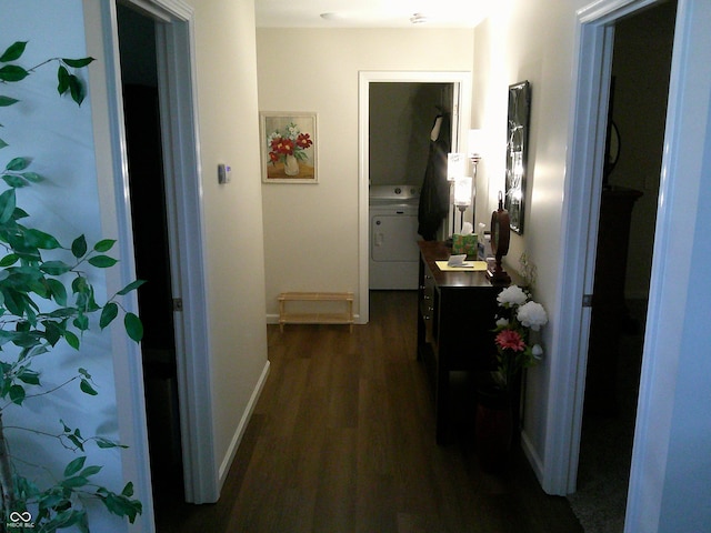 hall featuring dark wood-type flooring, washer / dryer, and baseboards