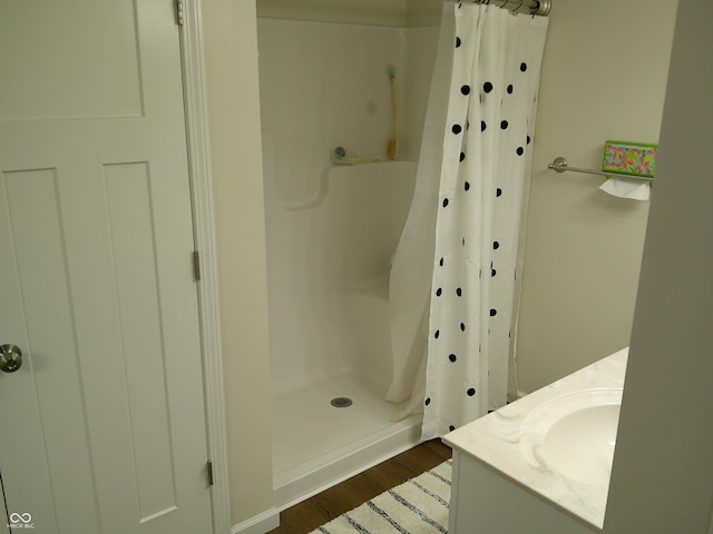 bathroom with a shower stall, vanity, and wood finished floors